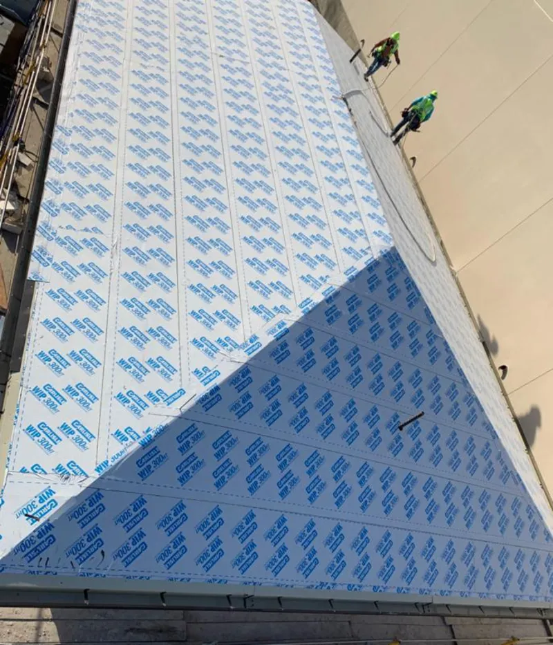 Professional roofers installing underlayment on a metal roof in Shelby